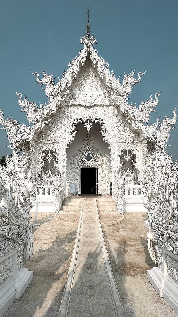 White Temple in Chiang Rai with intricate carvings and a central bridge.