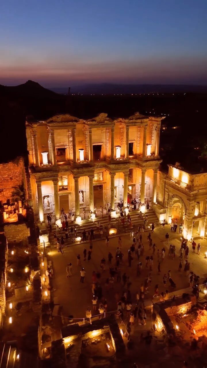 Library of Celsus facade illuminated at night with people gathered in the plaza