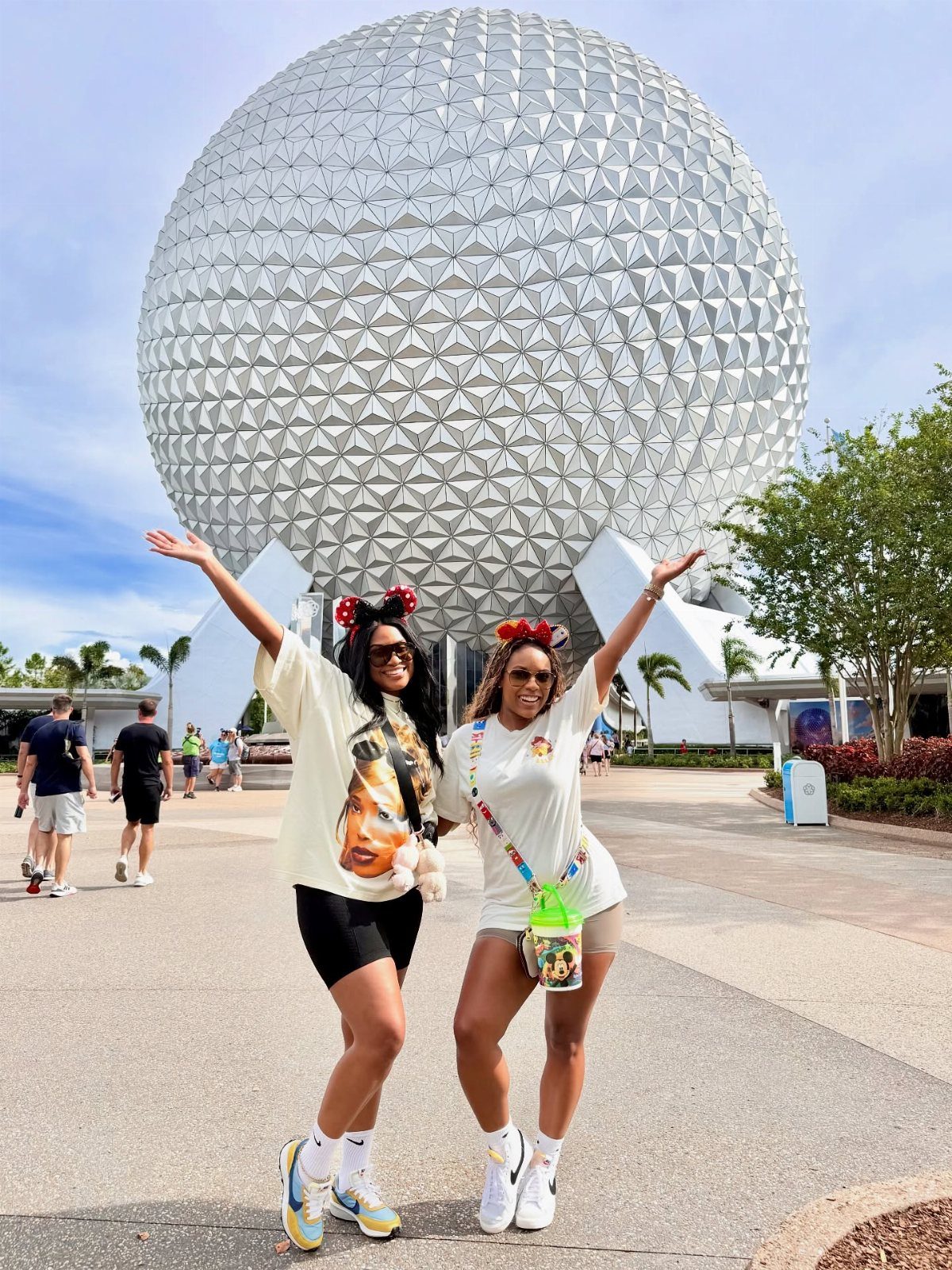 12 Vacation Ideas with Friends, from Cruises to Cancun 2 Two women posing in front of the Spaceship Earth sphere at Epcot Orlando.
