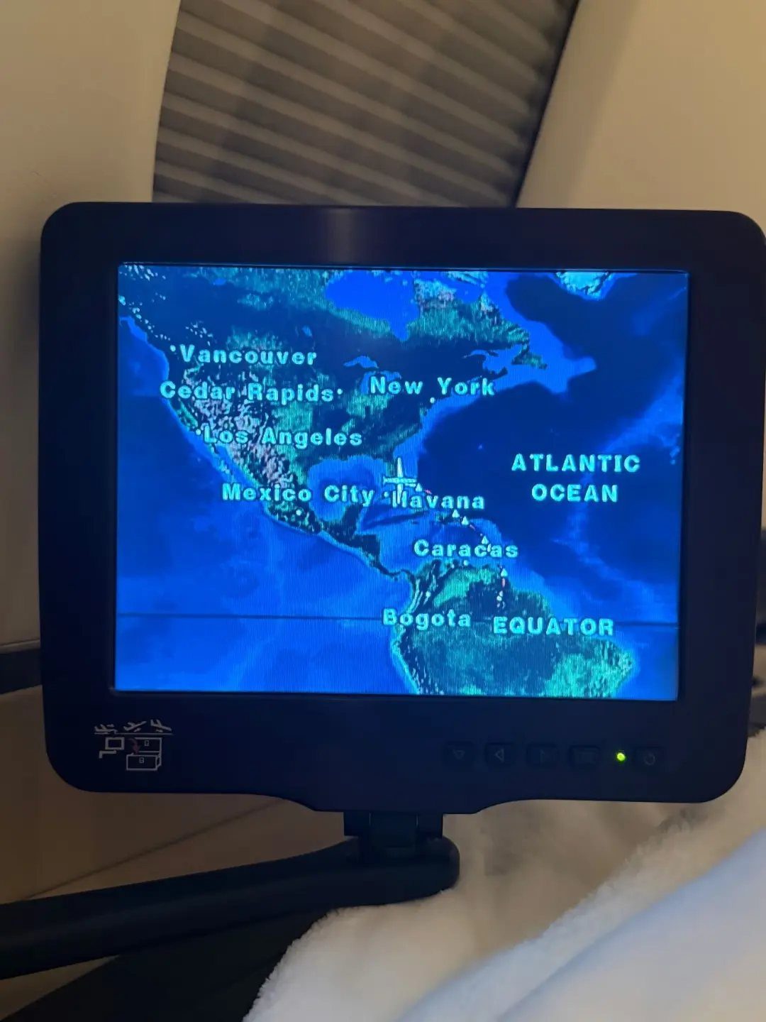 9 Ideas for What to Do on the Plane Besides Scrolling 2 In-flight entertainment screen displaying a blue digital map of the Americas.
