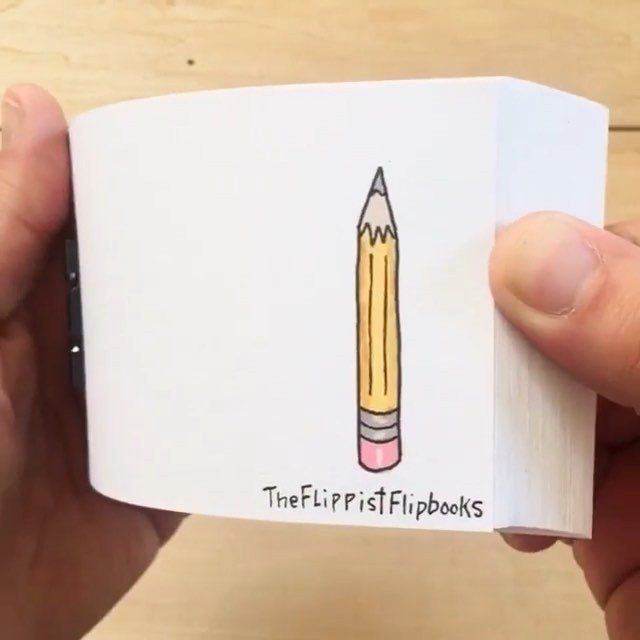 9 Ideas for What to Do on the Plane Besides Scrolling 4 Hands holding a white flipbook featuring a drawing of a yellow pencil.