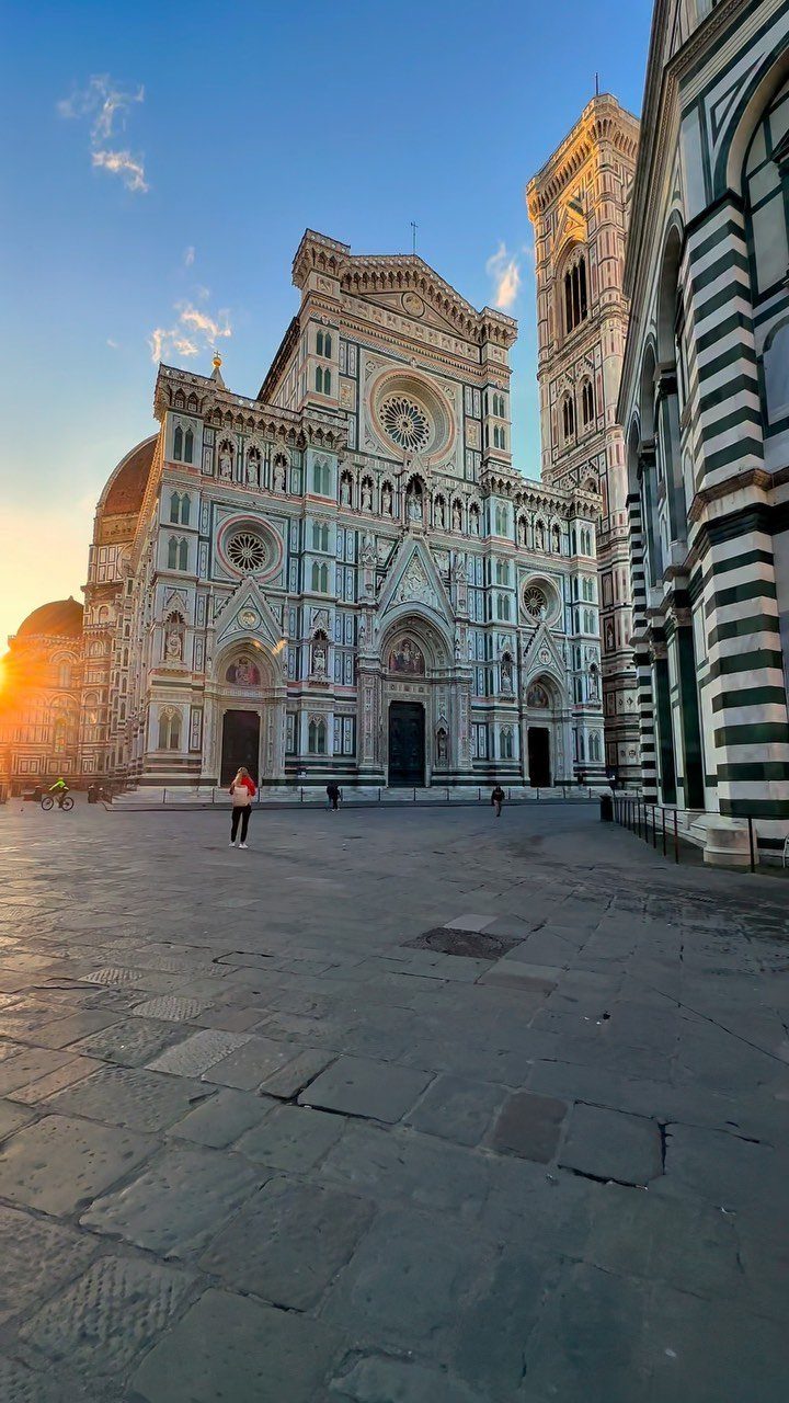 Florence Cathedral with its intricate marble facade and bell tower in a stone plaza