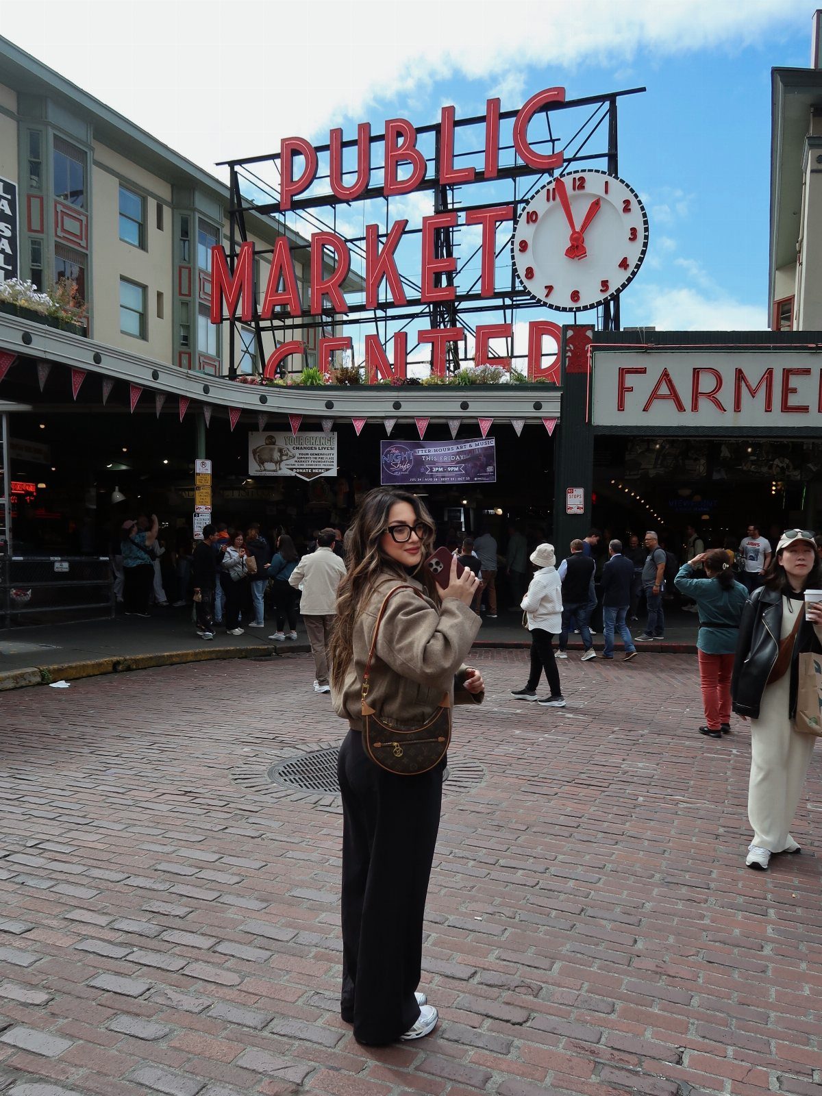 Woman posing in front of the Public Market Center sign in Seattle, Washington.
